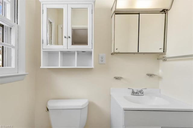 bathroom with plenty of natural light, toilet, and vanity