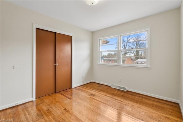 unfurnished bedroom featuring a closet and light hardwood / wood-style floors