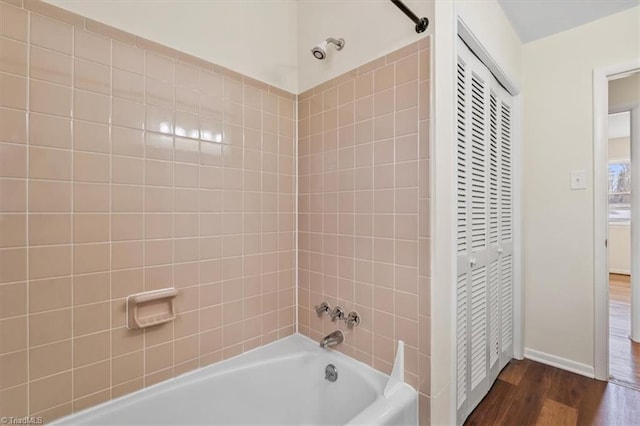 bathroom with tiled shower / bath and hardwood / wood-style floors