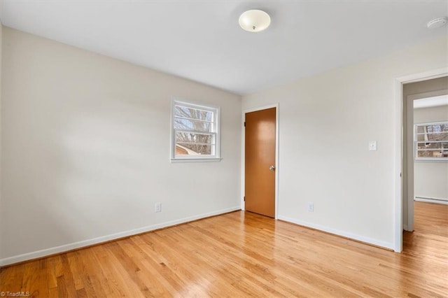 empty room featuring light wood-type flooring and baseboard heating