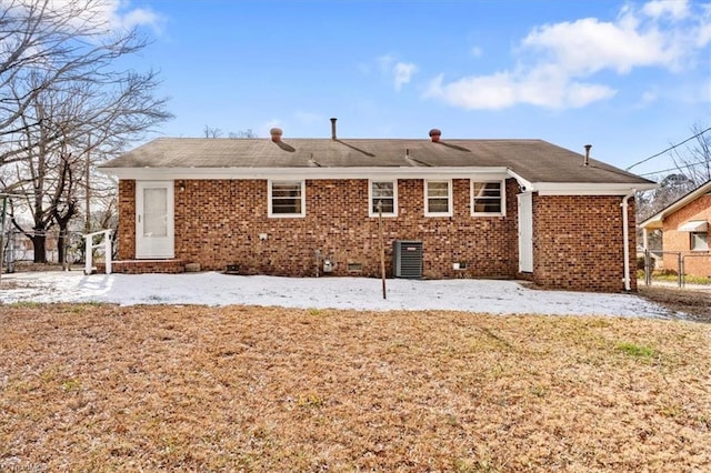 back of property with a lawn and central AC