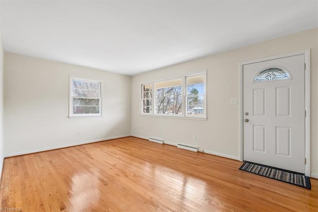 entrance foyer featuring baseboard heating and light hardwood / wood-style floors