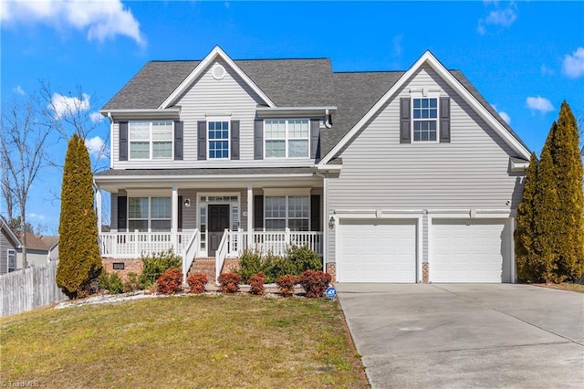 view of front of home featuring a garage, a front yard, and covered porch