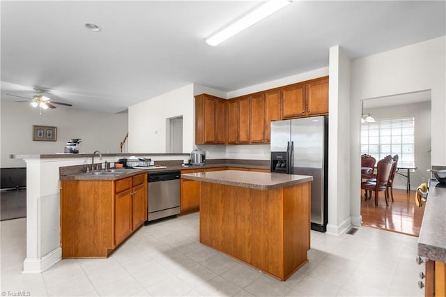 kitchen featuring sink, a center island, kitchen peninsula, ceiling fan, and stainless steel appliances