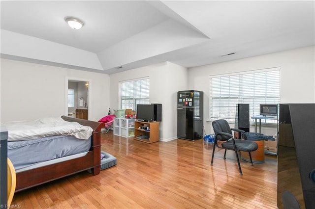 bedroom featuring hardwood / wood-style floors and a raised ceiling