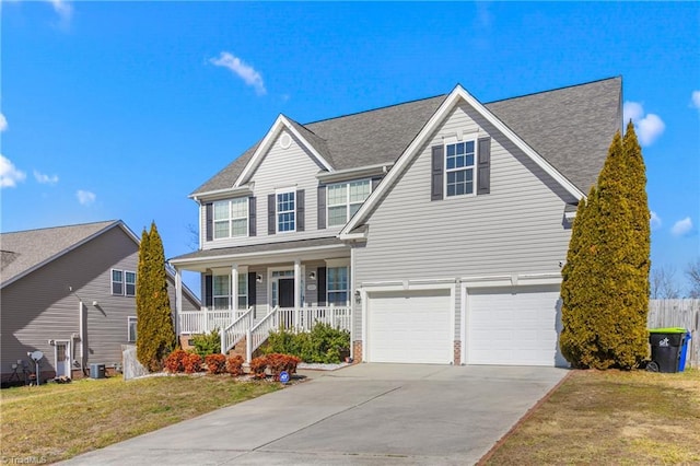 view of front of home with a porch, a garage, and a front lawn