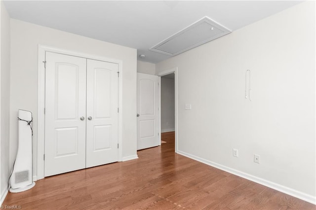 unfurnished bedroom with hardwood / wood-style flooring and a closet