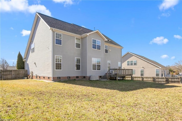 rear view of house with a wooden deck and a lawn