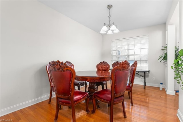 dining space with wood-type flooring and a chandelier