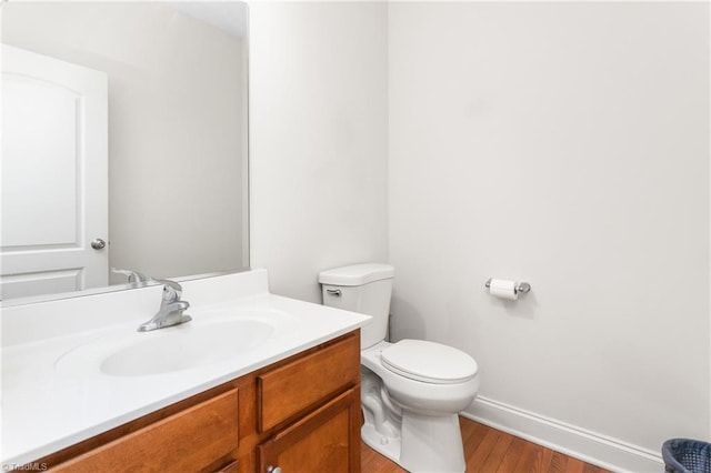 bathroom featuring vanity, wood-type flooring, and toilet