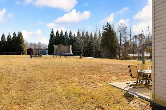 view of yard with a trampoline and a patio area