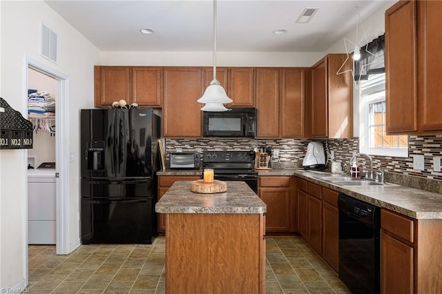 kitchen featuring a kitchen island, washer / clothes dryer, sink, hanging light fixtures, and black appliances