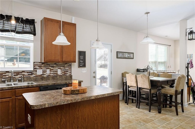 kitchen with sink, a center island, black dishwasher, tasteful backsplash, and decorative light fixtures