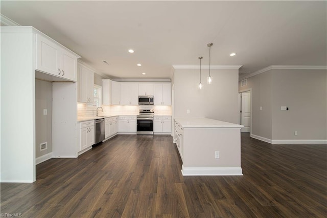 kitchen featuring sink, appliances with stainless steel finishes, white cabinetry, backsplash, and decorative light fixtures