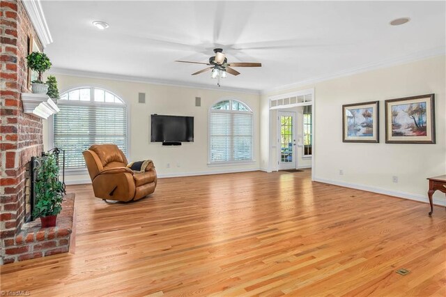 interior space with crown molding, light wood finished floors, baseboards, and a ceiling fan