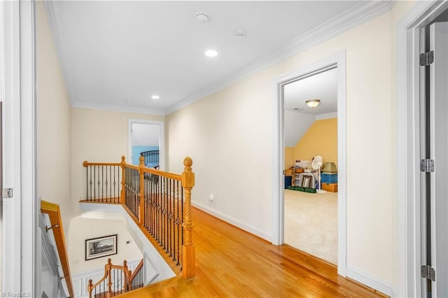 corridor with baseboards, ornamental molding, recessed lighting, an upstairs landing, and wood finished floors
