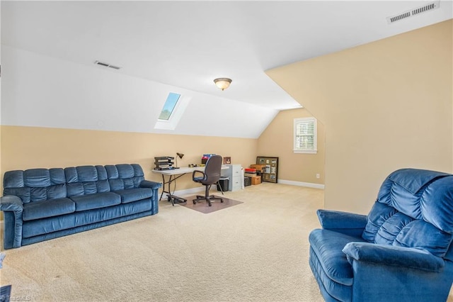 carpeted office space featuring visible vents, baseboards, and lofted ceiling with skylight
