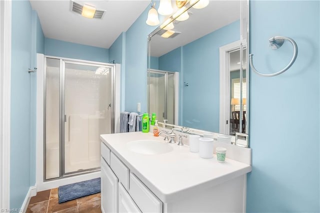 bathroom featuring visible vents, a stall shower, and vanity