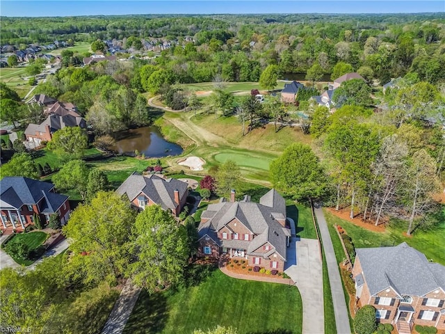 aerial view featuring a forest view, golf course view, a residential view, and a water view