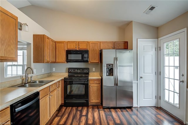 kitchen featuring dark wood-style flooring, a sink, light countertops, lofted ceiling, and black appliances