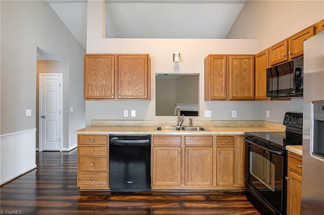 kitchen with a sink, light countertops, lofted ceiling, dark wood-style floors, and black appliances