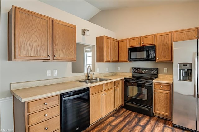 kitchen featuring dark wood-style flooring, a sink, light countertops, vaulted ceiling, and black appliances
