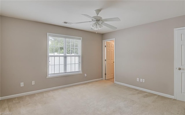 unfurnished room with visible vents, a ceiling fan, baseboards, and light colored carpet