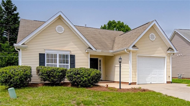 view of front of home featuring an attached garage, a front lawn, roof with shingles, and concrete driveway