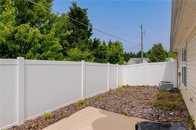 view of yard with central air condition unit, a fenced backyard, and a patio area