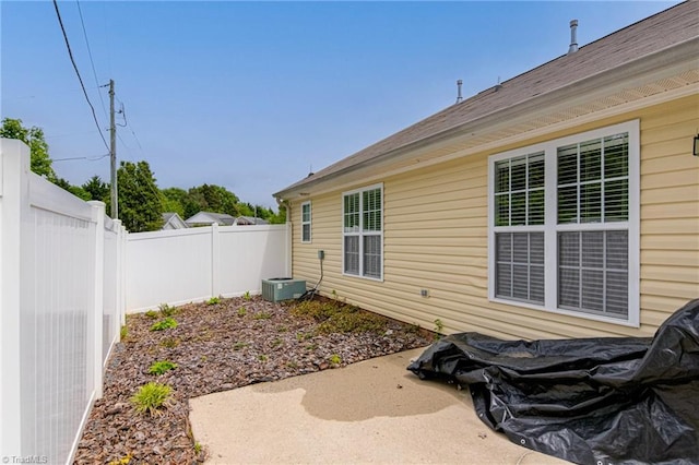 exterior space featuring a fenced backyard, a patio area, and cooling unit