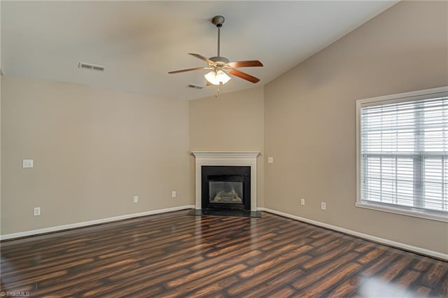 unfurnished living room featuring ceiling fan, visible vents, vaulted ceiling, wood finished floors, and baseboards