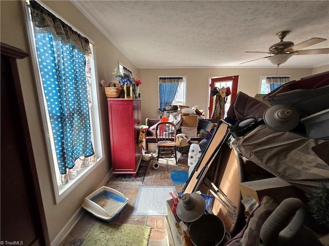 interior space featuring ceiling fan, baseboards, and a textured ceiling