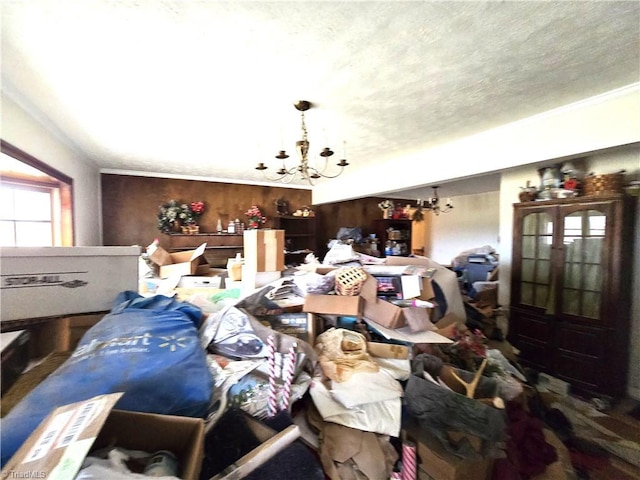 miscellaneous room with ornamental molding, a textured ceiling, and an inviting chandelier