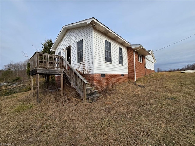 view of side of property featuring crawl space, stairs, and a deck