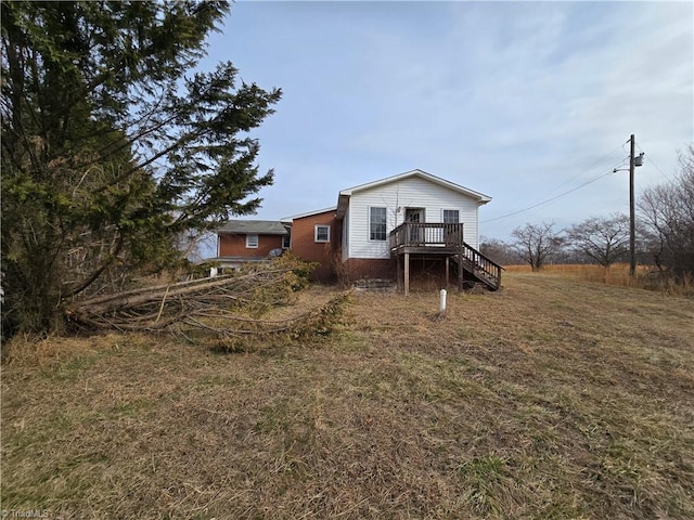 rear view of property with stairs and a wooden deck