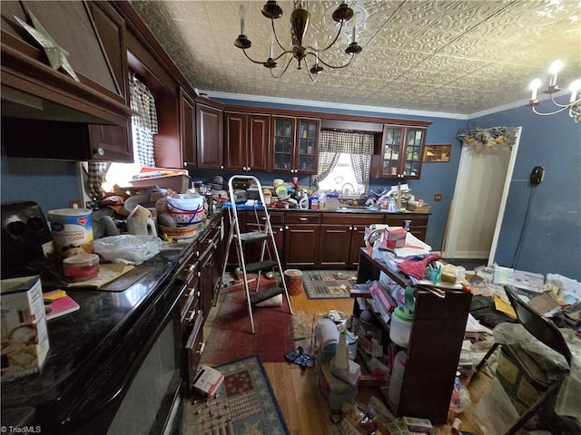 kitchen with ornamental molding, wood finished floors, an ornate ceiling, and an inviting chandelier