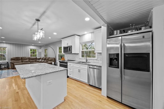 kitchen with white cabinets, a wealth of natural light, a sink, and appliances with stainless steel finishes