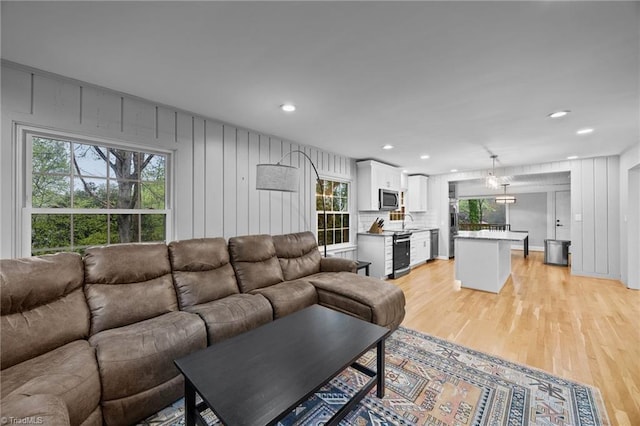 living room with light wood finished floors, recessed lighting, and a healthy amount of sunlight