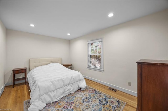 bedroom with recessed lighting, visible vents, baseboards, and wood finished floors