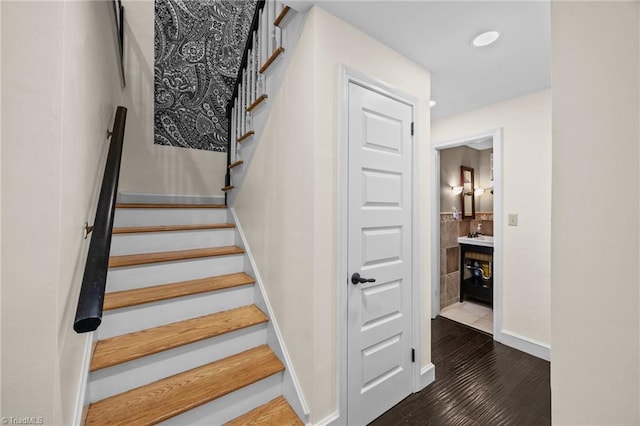 stairway featuring wood finished floors, baseboards, and recessed lighting