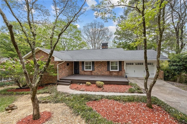 ranch-style home featuring a chimney, driveway, an attached garage, a porch, and brick siding