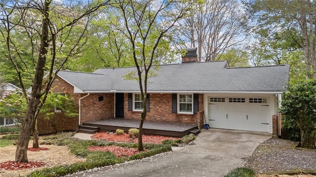 ranch-style house featuring a shingled roof, a garage, a chimney, brick siding, and driveway