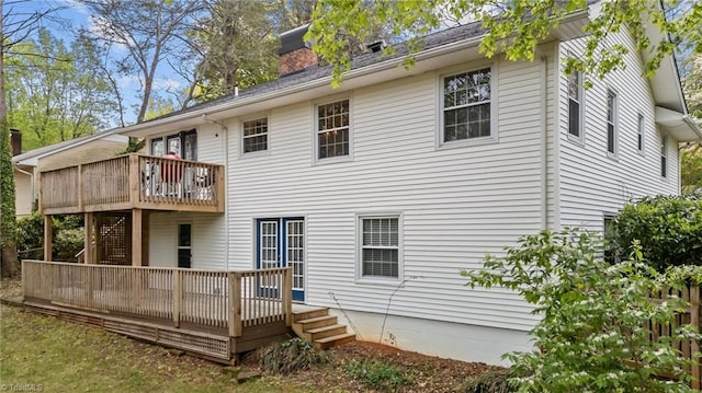 rear view of property featuring a deck and a chimney