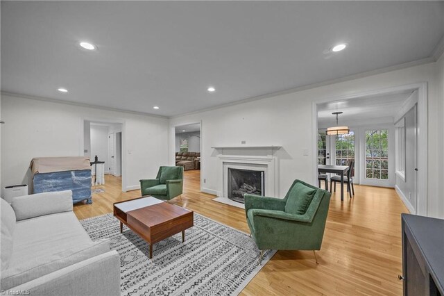 living area featuring ornamental molding, light wood finished floors, and recessed lighting