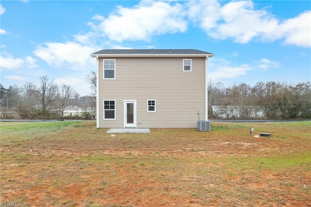 back of property featuring cooling unit and a yard