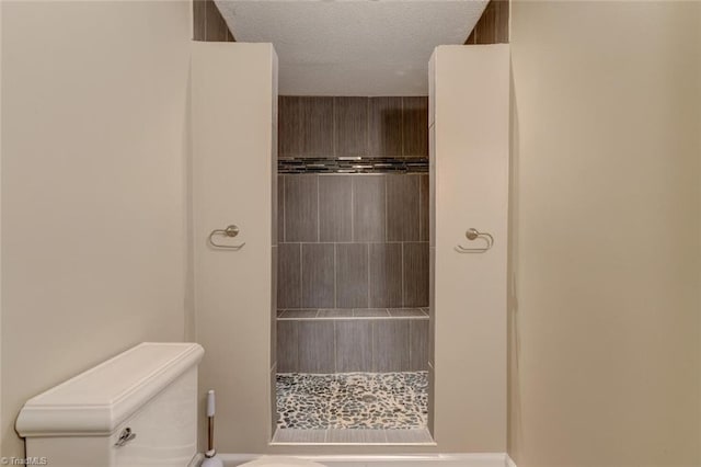2892 NC Highway 700, Pelham, NC 27311 - bathroom with a textured ceiling, a tile shower, and toilet