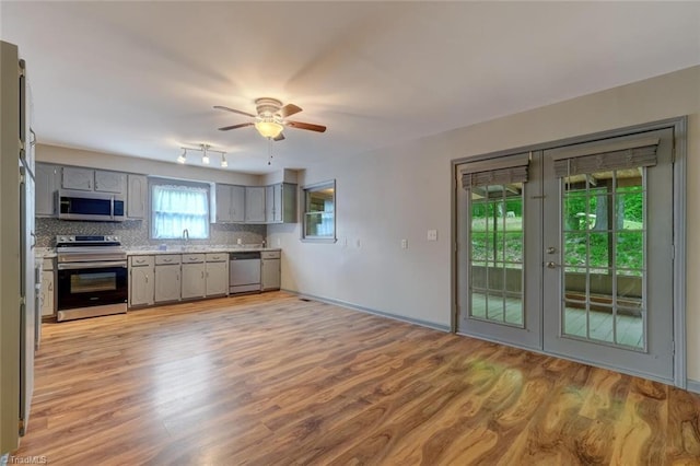 2892 NC Highway 700, Pelham, NC 27311 - kitchen with ceiling fan, appliances with stainless steel finishes, tasteful backsplash, gray cabinetry, and light wood-style floors