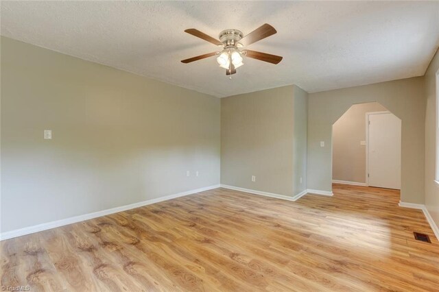 2892 NC Highway 700, Pelham, NC 27311 - empty room featuring light wood finished floors, arched walkways, a ceiling fan, baseboards, and visible vents