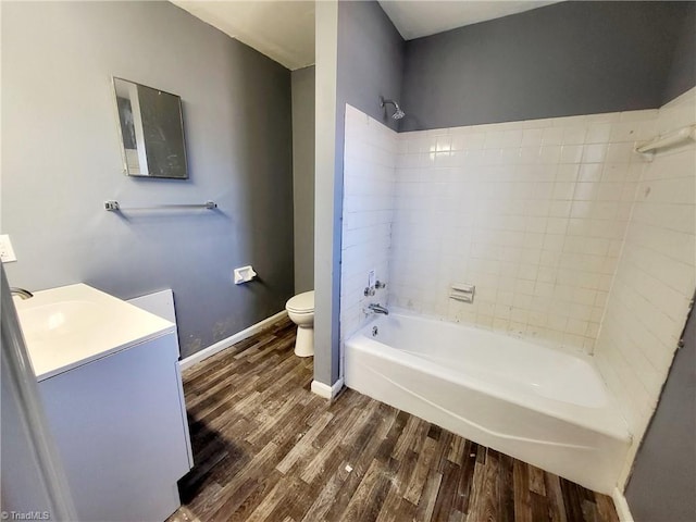 full bathroom with hardwood / wood-style floors, vanity, toilet, and tiled shower / bath