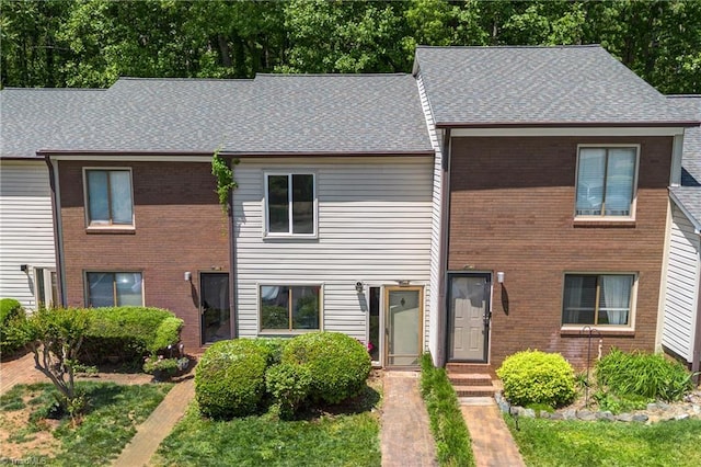 multi unit property with brick siding and roof with shingles